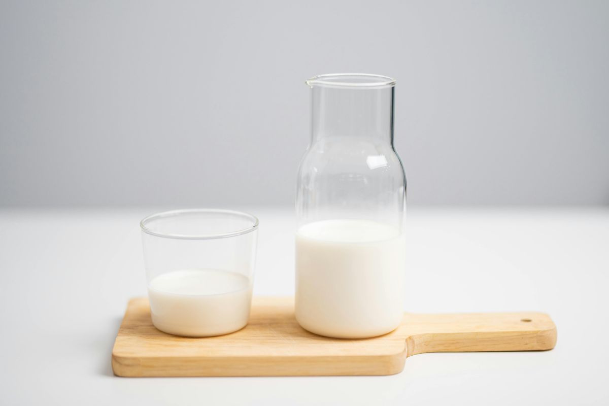 1. Ce nu ai voie sa mananci cand iei antibiotic Alimente interzise (lactate, alcool) si recomandari pentru protectia stomacului Sticla si pahar cu lapte aranjate pe un tocator din lemn