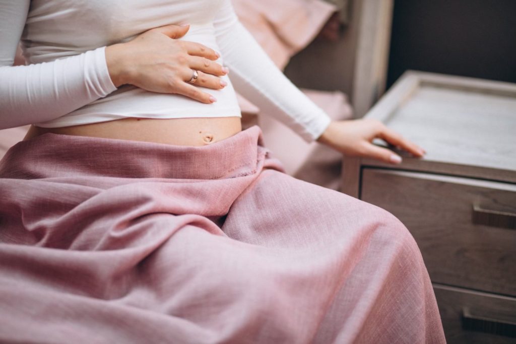 5. Hidronefroza la copii si in sarcina (femeie insarcinata care isi atinge burta, infectie urinara, patura roz)
