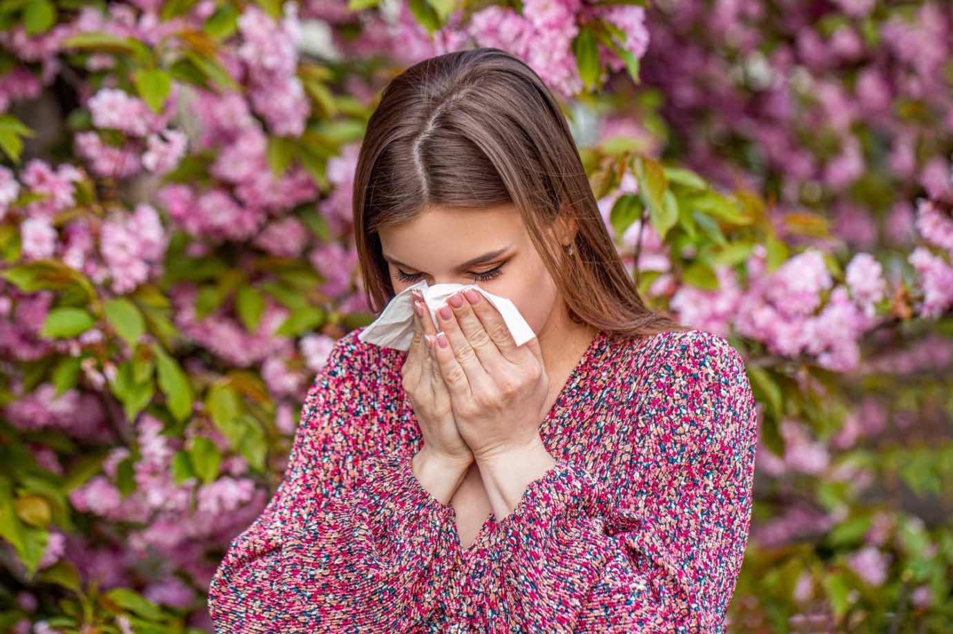 Ce vitamine sunt esentiale (femeie care isi sufla nasul, alergii de primavara, pom inflorit)