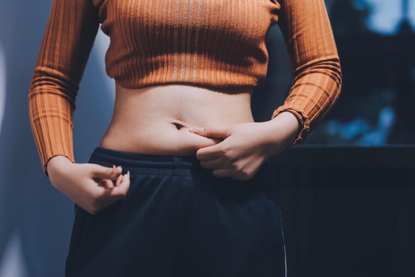 Tesutul adipos (femeie care isi atinge abdomenul, grasime abdominala, maleta caramizie)