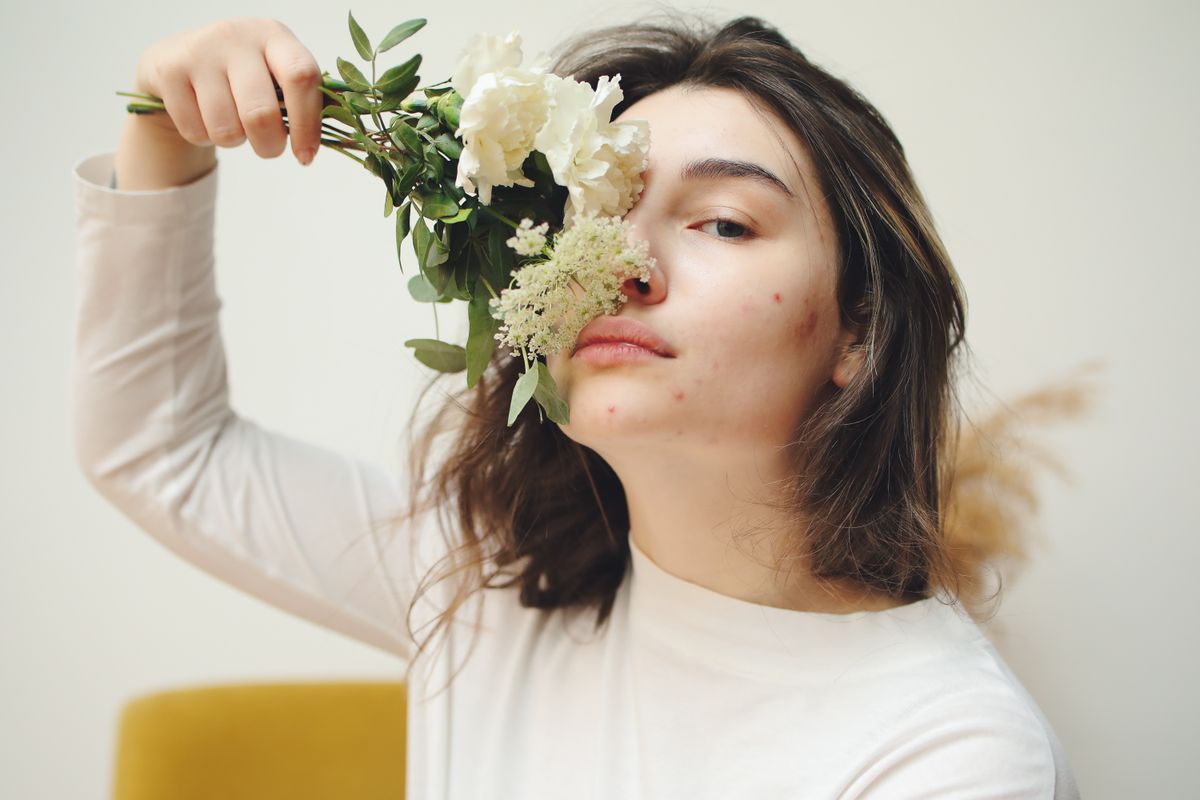 Cosuri inainte de menstruatie (femeie care tine un buchet de flori in dreptul fetei, cosuri hormonale, maleta alba)