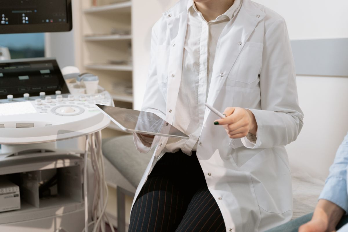 Hormonii si sanatatea (medic care discuta cu o pacienta, date medicale pe tableta, echipament medical modern)