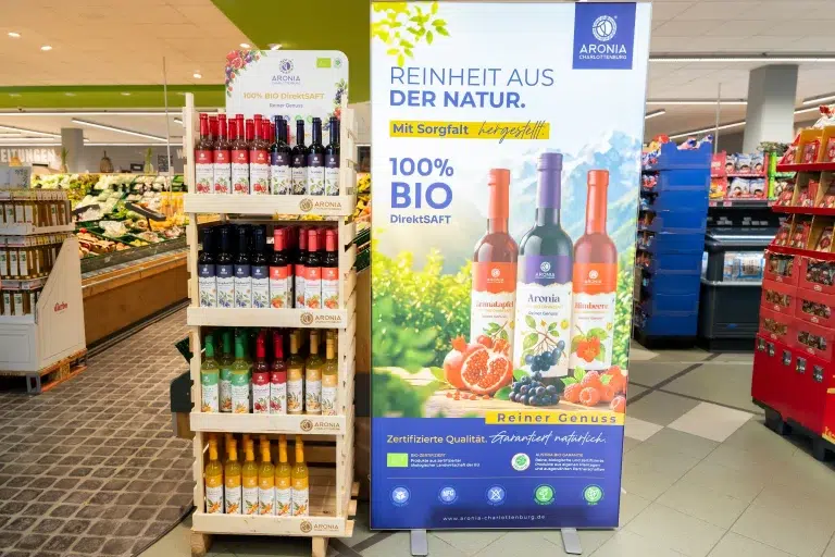 Raftul și bannerul Aronia Charlottenburg într-un supermarket din München